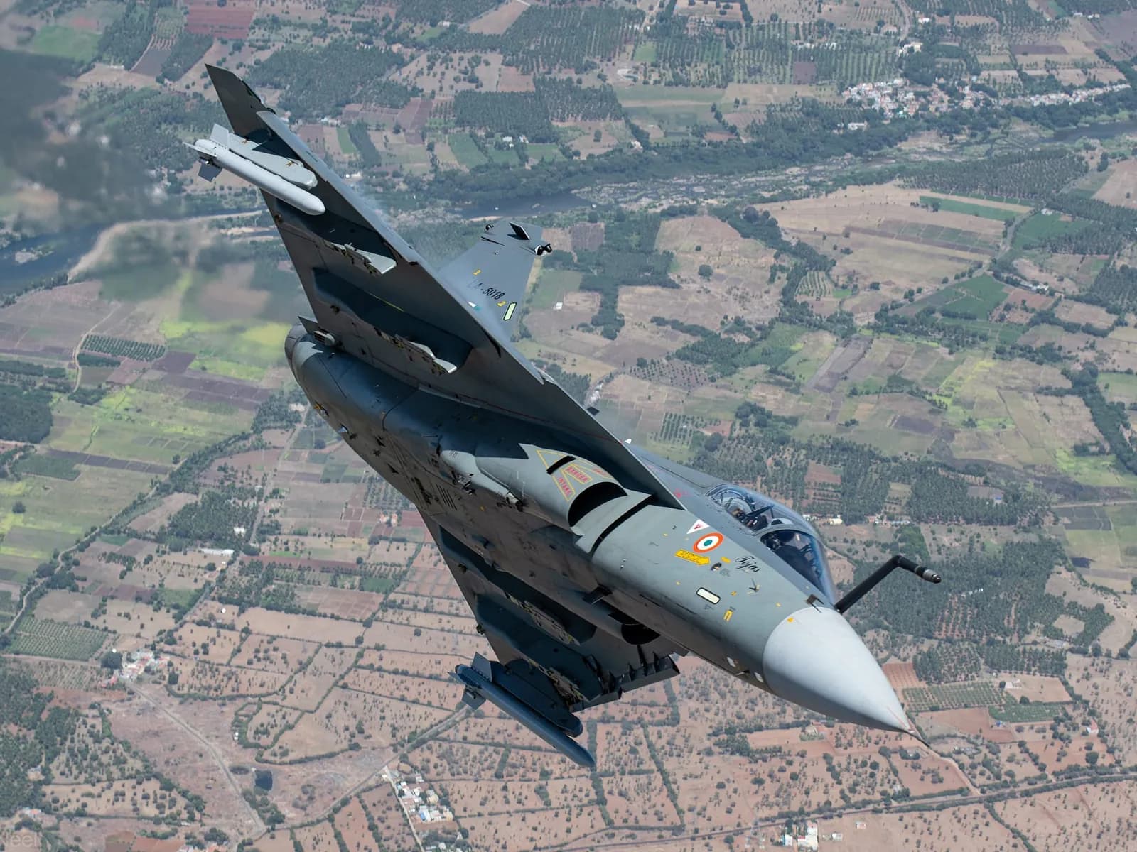 HAL Tejas fighter aircraft banking over farmland